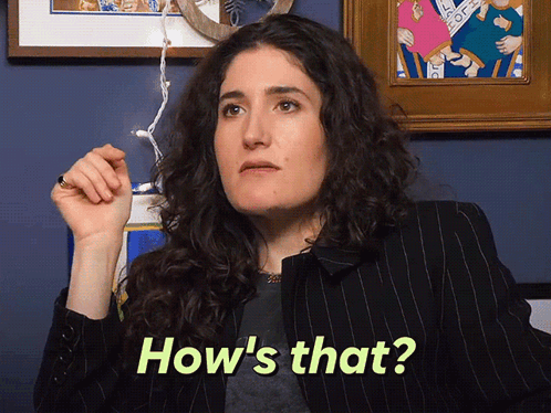 A Woman Says How 'S That While Holding A Pen GIF