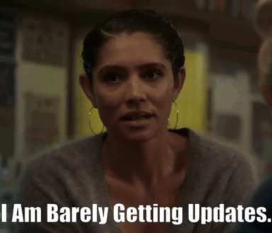 A Woman Says " I Am Barely Getting Updates " In Front Of A Bookshelf GIF