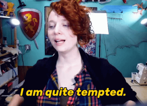 A Woman Says " I Am Quite Tempted " In Front Of A Blue Wall GIF