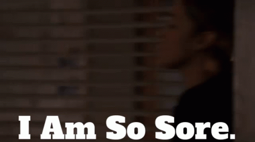 A Woman Says I Am So Sore In Front Of A Brick Wall GIF