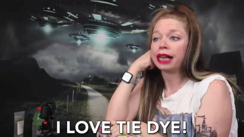 A Woman Says I Love Tie Dye In Front Of A Picture Of Aliens GIF
