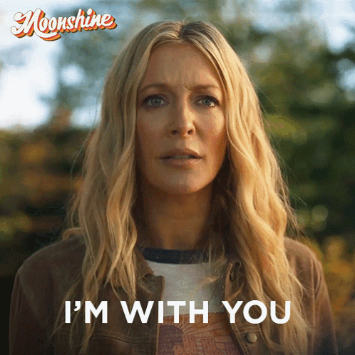 A Woman Says " I 'M With You " In Front Of A Poster For Moonshine GIF