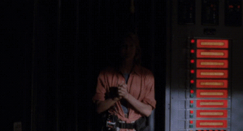 A Woman Says " I Think We 'Re Back In Business " In A Dark Room GIF