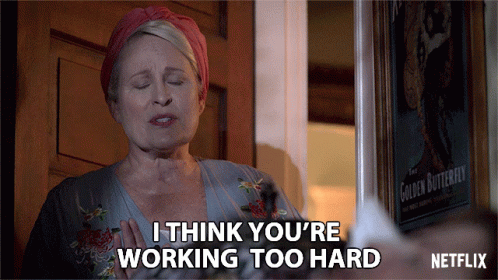 A Woman Says I Think You 'Re Working Too Hard In Front Of A Poster Of The Golden Butterfly GIF