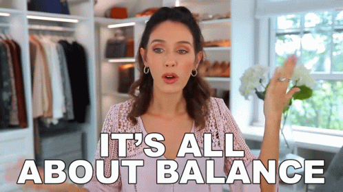 A Woman Says It 'S All About Balance In Front Of A Closet Full Of Clothes GIF
