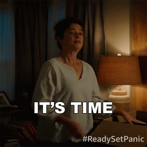 A Woman Says It 'S Time While Standing Next To A Lamp GIF
