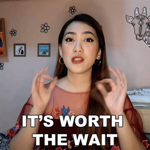 A Woman Says It 'S Worth The Wait In Front Of A Picture Of A Giraffe GIF