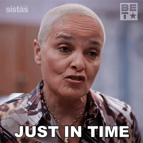 a woman says just in time while wearing a shirt and necklace