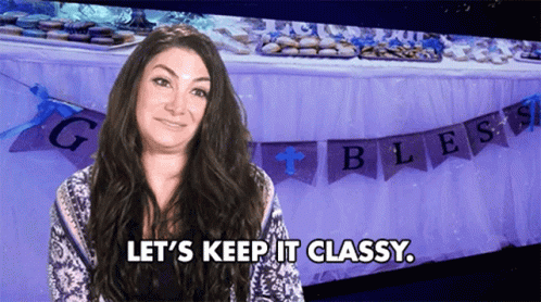 A Woman Says Let 'S Keep It Classy In Front Of A Table With Banners That Say Bless GIF