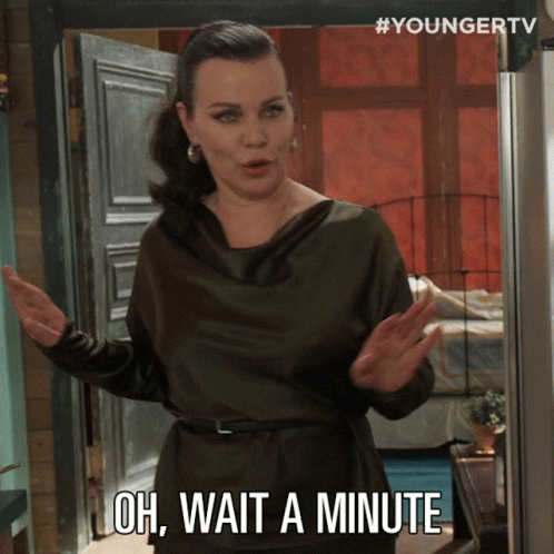 A Woman Says Oh Wait A Minute While Standing In Front Of A Door GIF