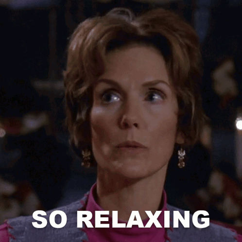 A Woman Says She Is So Relaxing In Front Of A Dark Background GIF