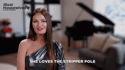 A Woman Says She Loves The Stripper Pole In Front Of A Piano And Couch GIF