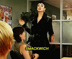 A Woman Says Smackwich While Standing In Front Of A Group Of People GIF