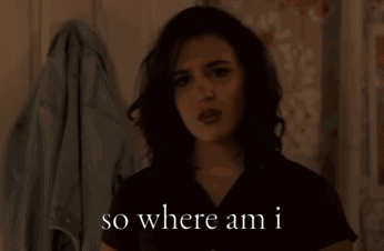 a woman says " so where am i " while standing in front of a wall