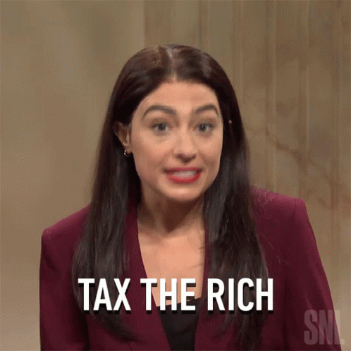 A Woman Says " Tax The Rich " While Wearing A Maroon Suit GIF