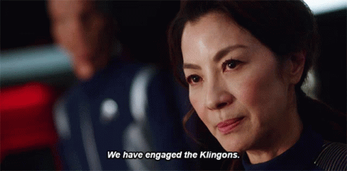 A Woman Says " We Have Engaged The Klingons " In Front Of A Man GIF