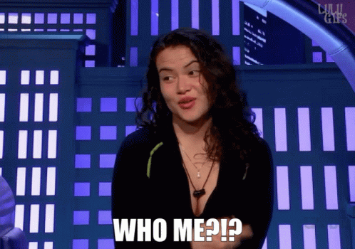 A Woman Says " Who Me ? " In Front Of A Building GIF