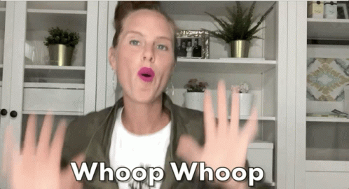 A Woman Says Whoop Whoop In Front Of A Bookshelf GIF