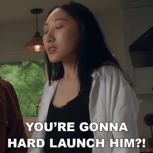 A Woman Says " You 'Re Gonna Hard Launch Him " In A Kitchen GIF