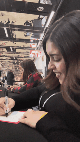 A Woman Signing A Piece Of Paper With A Marker GIF