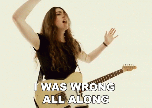 a woman singing and playing a guitar with the words i was wrong all along below her
