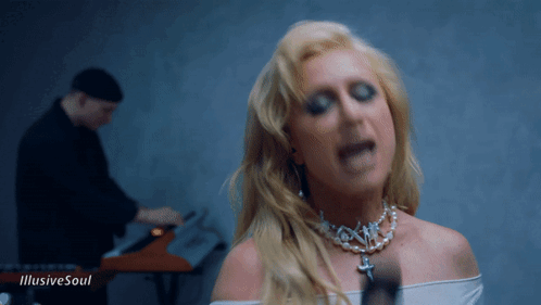 A Woman Singing In Front Of A Man Playing A Keyboard With The Words " Illusive Soul " On The Bottom GIF