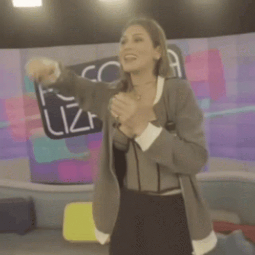 A Woman Singing Into A Microphone In Front Of A Fofo Sign GIF