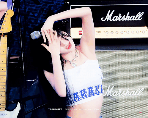 A Woman Singing Into A Microphone In Front Of A Marshall Amp GIF