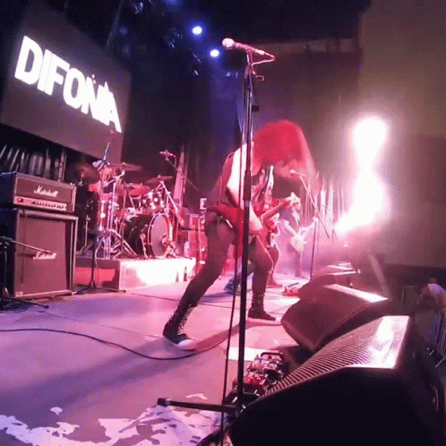 a woman singing into a microphone in front of a sign that says " difona "