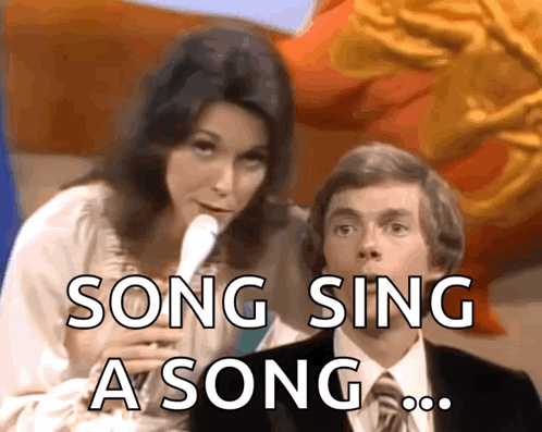A Woman Singing Into A Microphone Next To A Man With The Words Song Sing A Song GIF