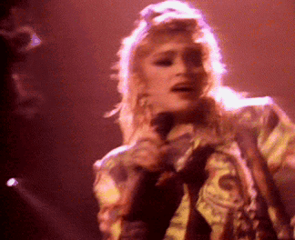 a woman singing into a microphone on stage