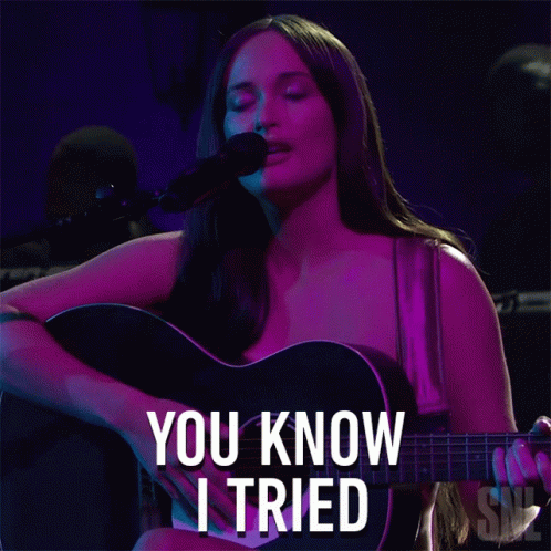 A Woman Singing Into A Microphone While Holding A Guitar With The Words You Know I Tried Written Below Her GIF