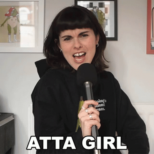 A Woman Singing Into A Microphone With Atta Girl Written On The Bottom Right GIF