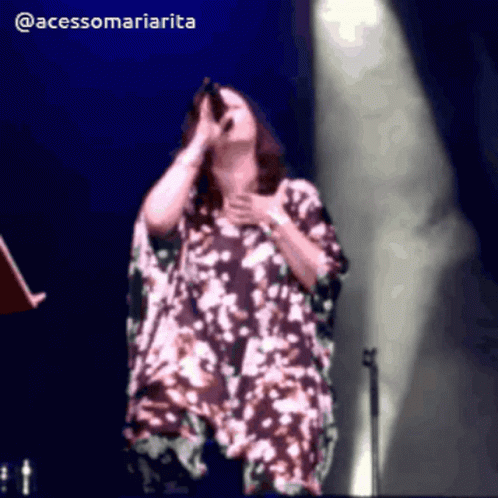 A Woman Singing Into A Microphone With The Hashtag @Acessomariaria GIF
