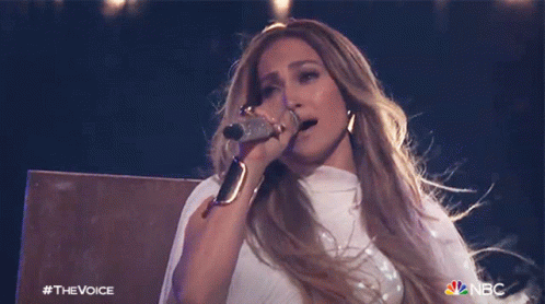 A Woman Singing Into A Microphone With The Nbc Logo On The Bottom Right GIF