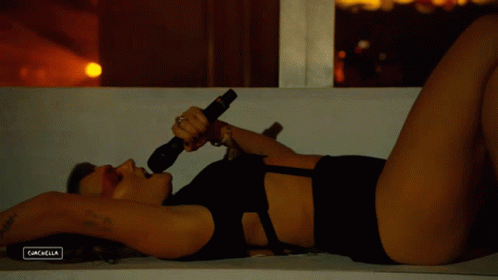 A Woman Singing Into A Microphone With The Word Cachella On The Bottom Left GIF