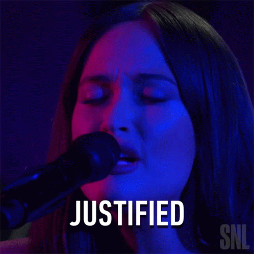 A Woman Singing Into A Microphone With The Word Justified Written Above Her GIF