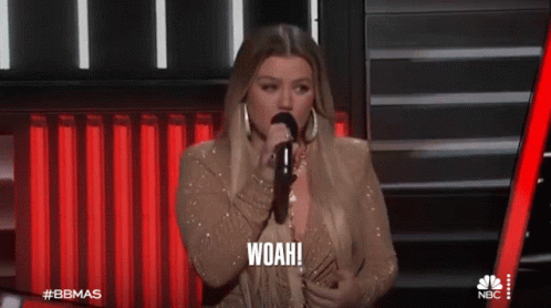 A Woman Singing Into A Microphone With The Word Woah On The Bottom GIF