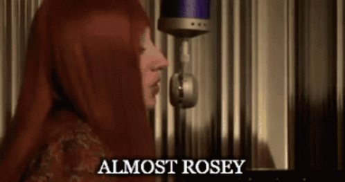 A Woman Singing Into A Microphone With The Words " Almost Rosey " On The Bottom GIF