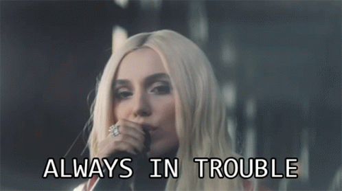 Woman Singing Into Microphone With Always In Trouble Text GIF