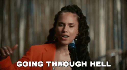 A Woman Singing Into A Microphone With The Words Going Through Hell Written Below Her GIF