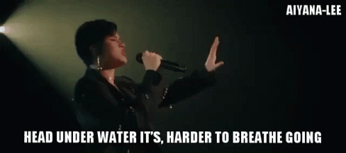 A Woman Singing Into A Microphone With The Words " Head Under Water It 'S Harder To Breathe Going " GIF