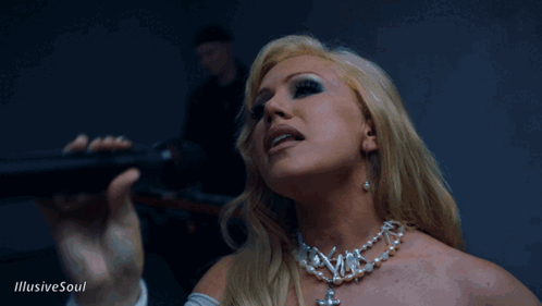 A Woman Singing Into A Microphone With The Words Illusive Soul On The Bottom Right GIF