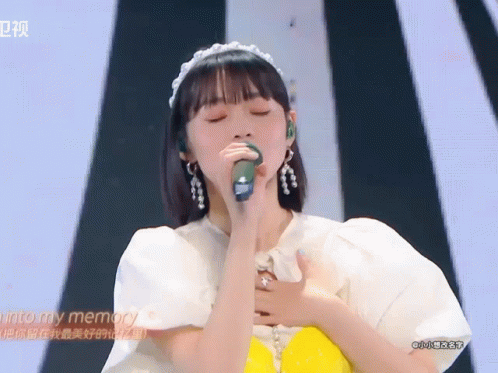 A Woman Singing Into A Microphone With The Words Into My Memory Written On The Bottom GIF