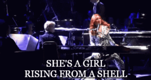 A Woman Singing Into A Microphone With The Words She 'S A Girl Rising From A Shell On The Bottom GIF