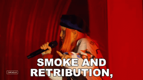 A Woman Singing Into A Microphone With The Words " Smoke And Retribution " Above Her GIF