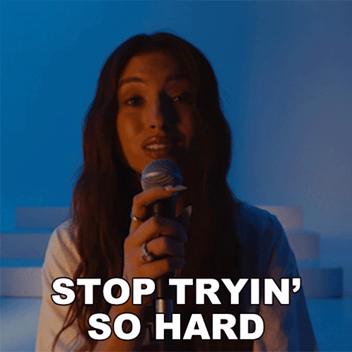 A Woman Singing Into A Microphone With The Words Stop Tryin ' So Hard Written Below Her GIF