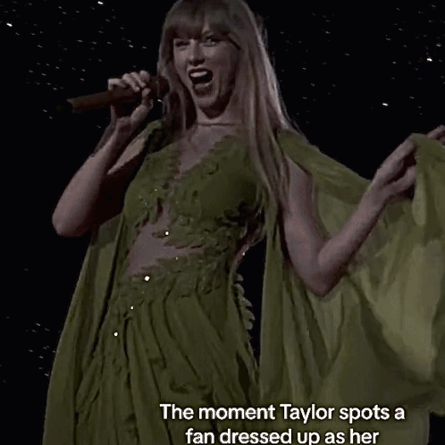 A Woman Singing Into A Microphone With The Words " The Moment Taylor Spots A Fan Dressed Up As Her " GIF