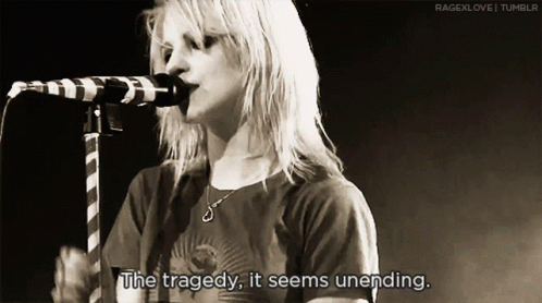 A Woman Singing Into A Microphone With The Words " The Tragedy It Seems Unending " GIF
