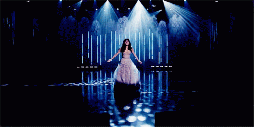A Woman Singing On A Stage With The Words Let Her Go Can 'T Be Obsessed Anymore Below Her GIF